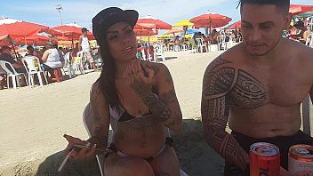 play La brune tatouée fait une pipe sur la plage et avale sloboz